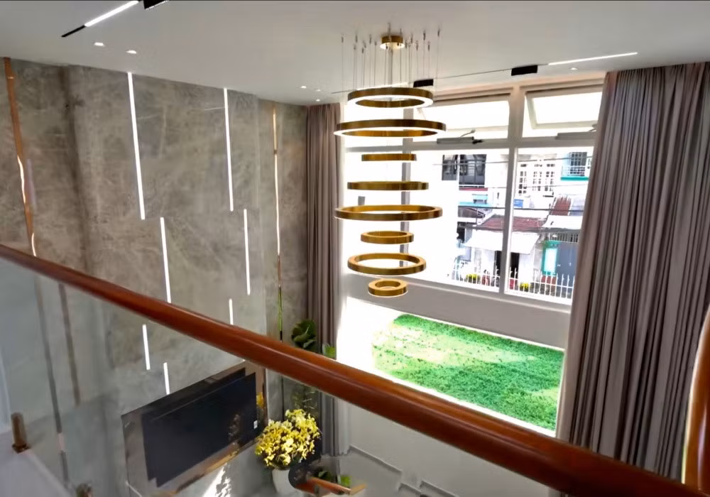 Mỗi tầng là không gian riêng tư cho một gia đình nhỏ, có thang máy và cầu thang uốn bọc inox màu đồng như một điểm nhấn trang trí. Ảnh: Vietnamnet