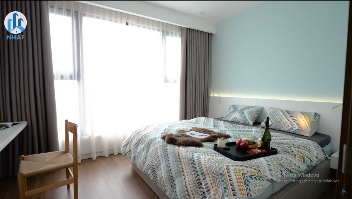 Phòng ngủ phụ có cửa kính lớn, nhìn thẳng ra không gian bên ngoài khu dô thị.