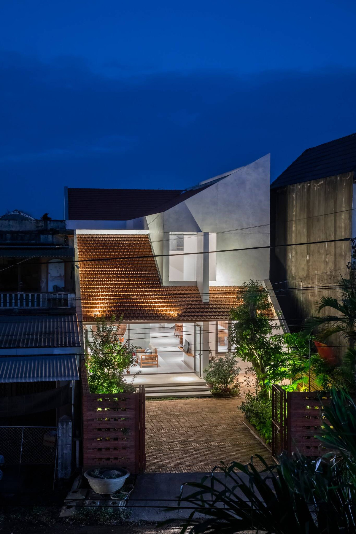 Ranh giới giữa bên trong và bên ngoài của ngôi nhà ống có tính kết nối nhiều hơn nhờ hàng rào gạch mộc.