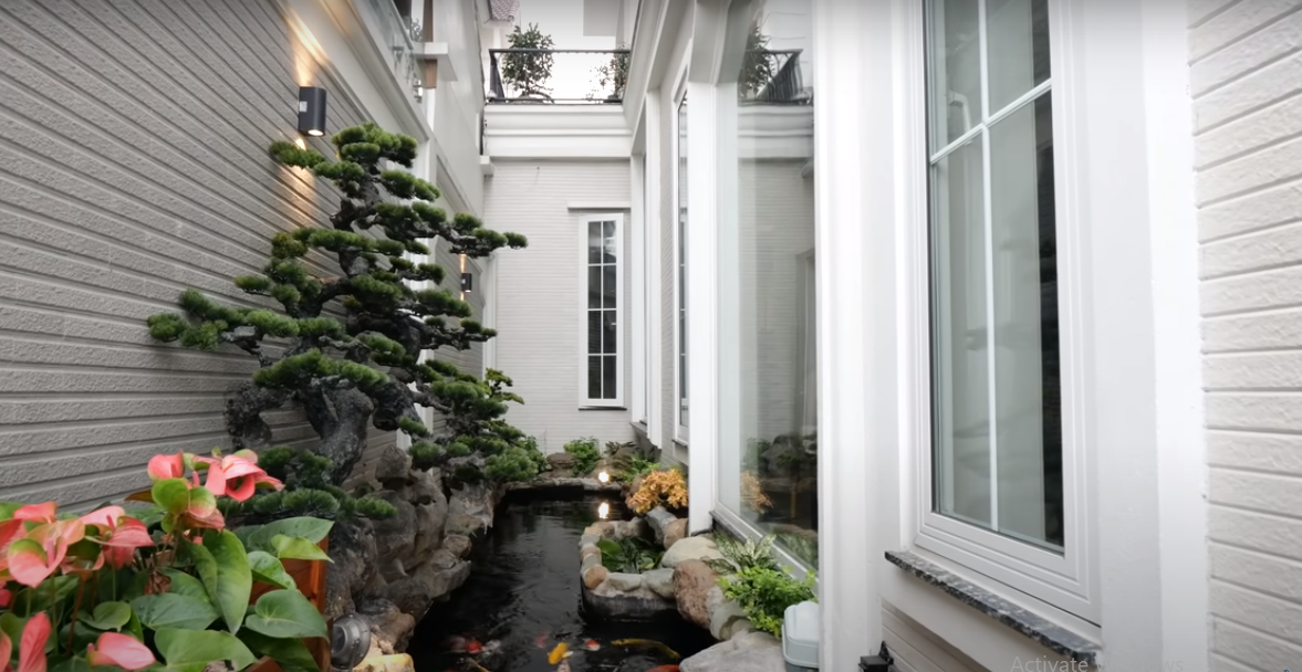 Khoảng không nhỏ bên cạnh được thiết kế một hồ cá Koi nhỏ, tạo không gian xanh và điều hoà không khí.