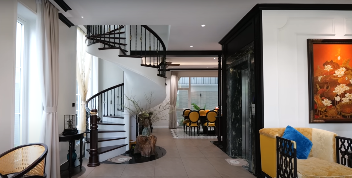 Ngoài thang máy để di chuyển giữa các tầng, ngôi biệt thự còn thiết kế cầu thang xoắn tạo điểm nhấn cho không gian tầng 1.