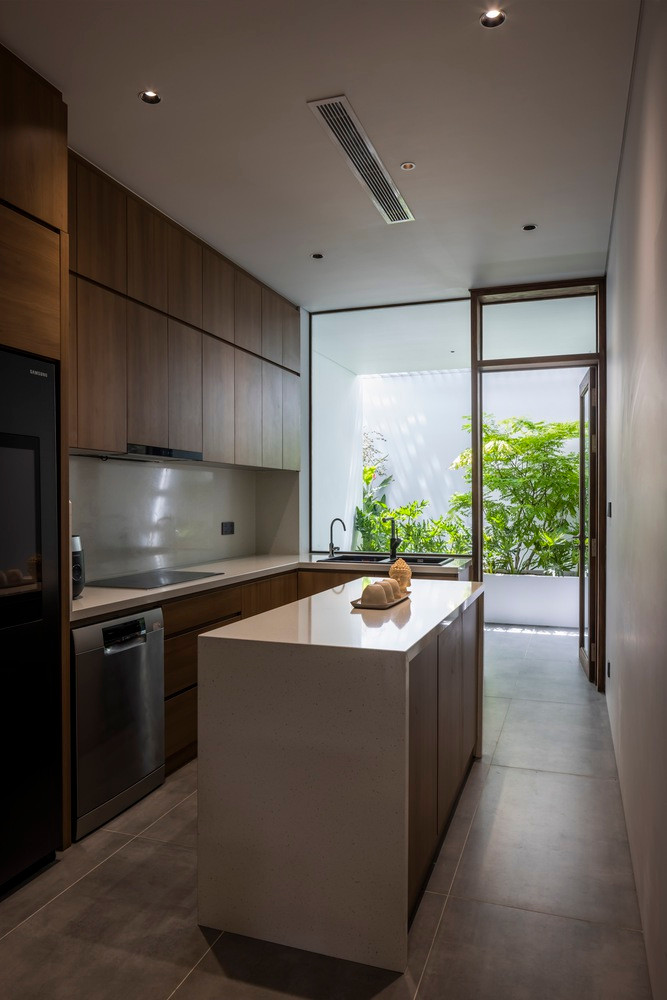 Khu vực bếp thoáng đãng, nhìn ra khoảng thông tầng với cây cối xanh mướt.