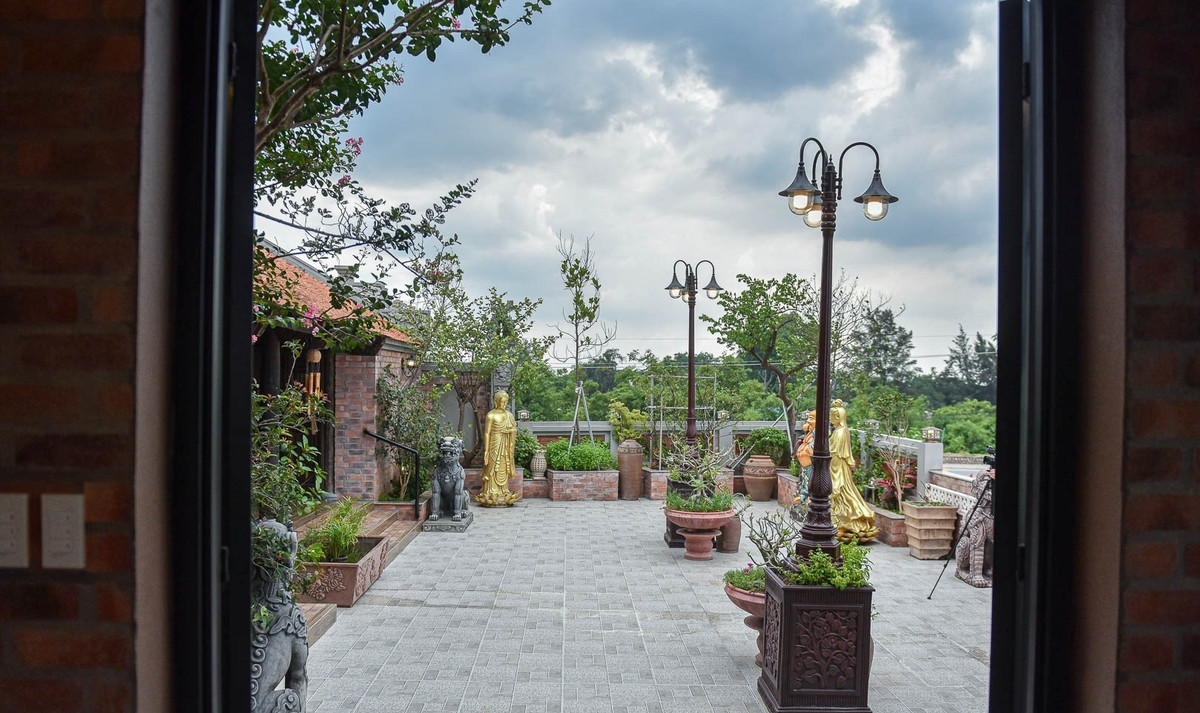 Khuôn viên nhà cổ trên sân thượng được trang trí thêm tiểu cảnh, hồ cá... và trưng bày một số sản phẩm điêu khắc. Ảnh: Dân trí