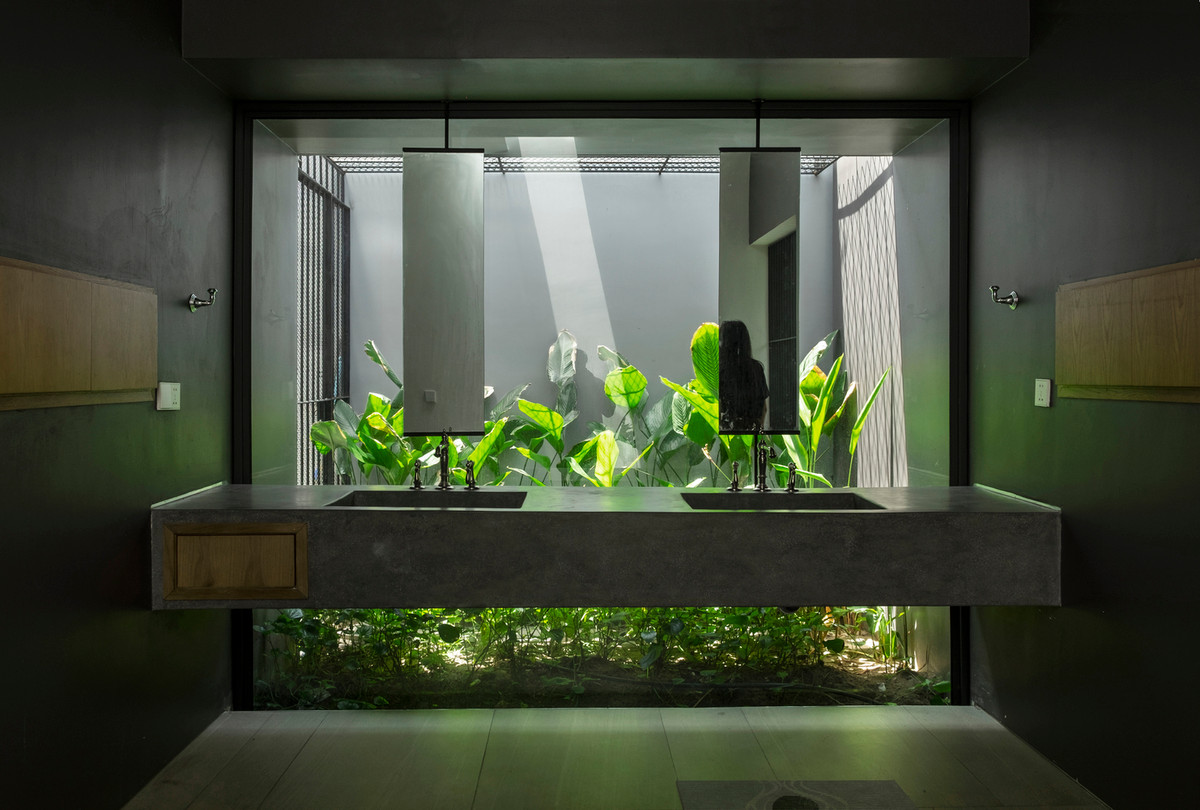 Phòng vệ sinh thiết kế mở có tầm nhìn ra khu vườn phía sau. Nguồn ảnh: TAA DESIGN