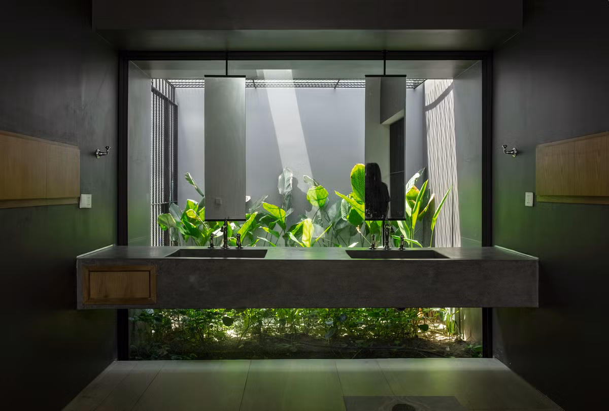 Phòng vệ sinh thiết kế mở có tầm nhìn ra khu vườn phía sau. Nguồn ảnh: TAA DESIGN