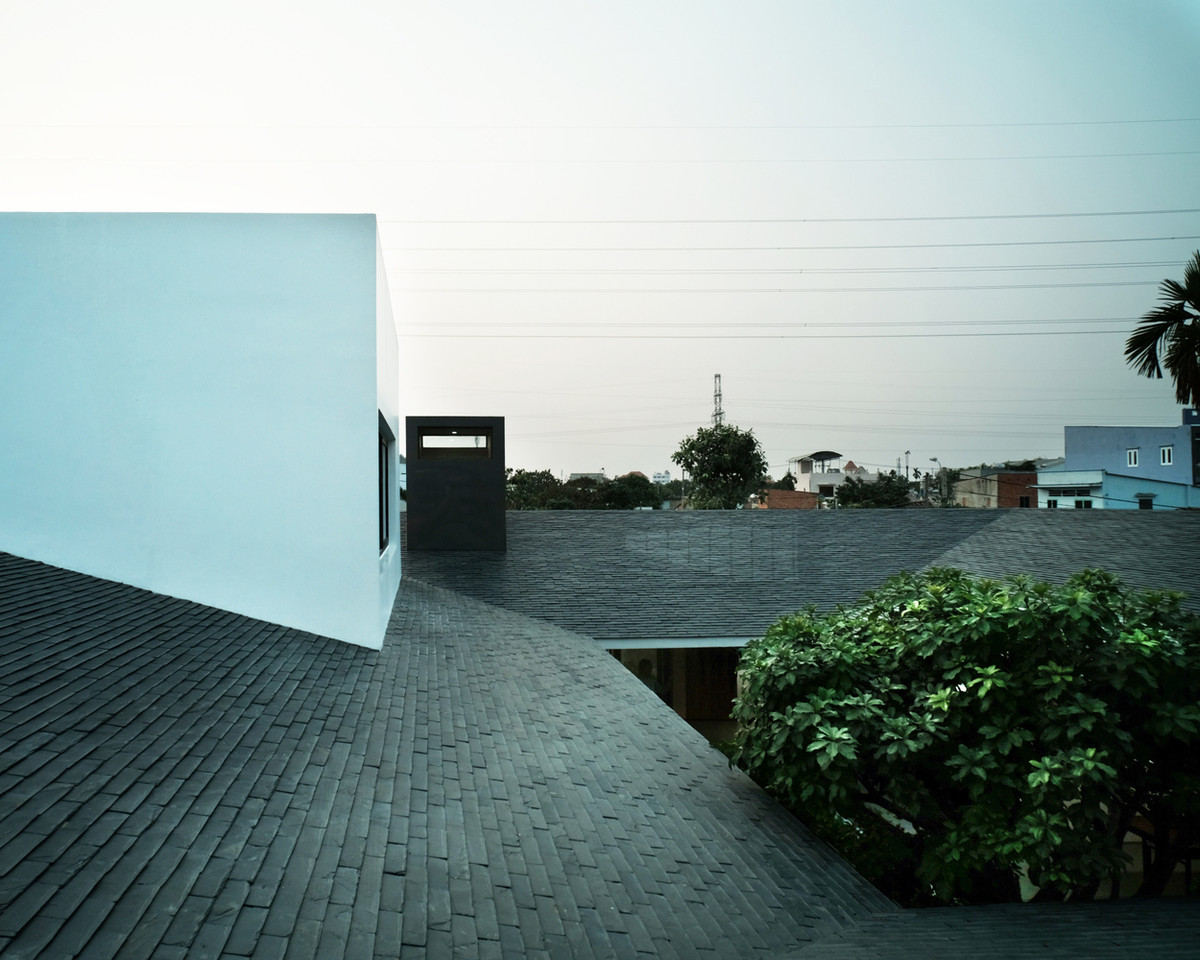 Những khối hộp hiện đại nổi bật trên phần mái dốc có vẻ truyền thống, xù xì.