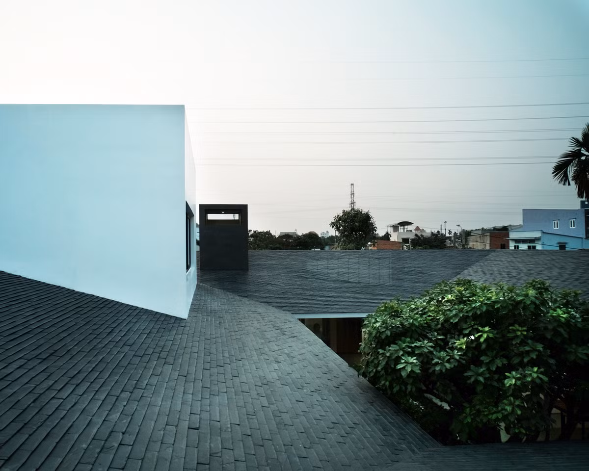 Những khối hộp hiện đại nổi bật trên phần mái dốc có vẻ truyền thống, xù xì.