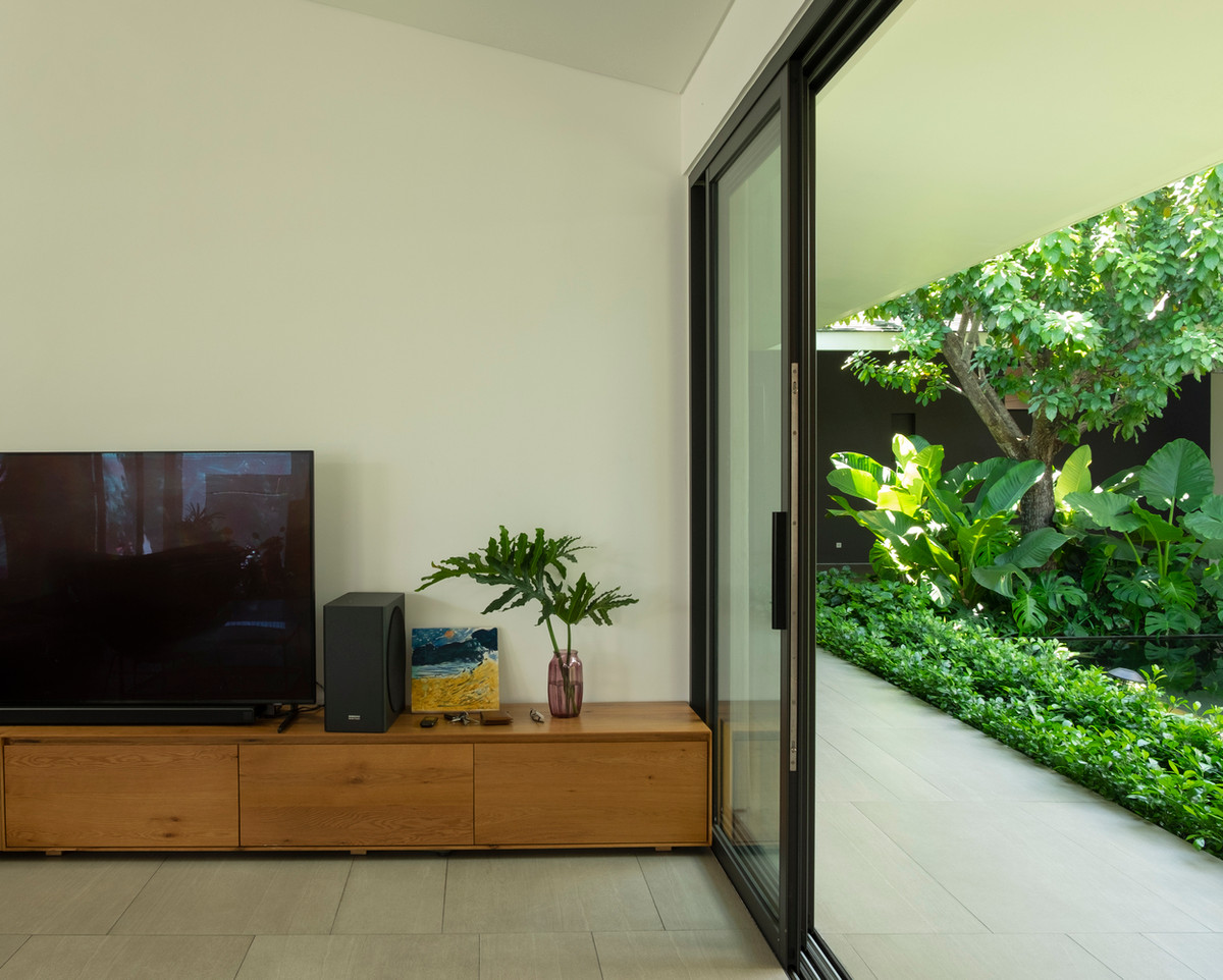 Đồng thời, cách bố trí tường lệch tạo không gian sân chung lớn nhỏ đa dạng dưới mái dốc, không vách ngăn với sân vườn, ánh nắng và cây xanh.