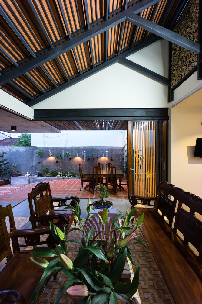 Hệ khung kết cấu được gia cố bởi dàn kèo thép có khoảng vượt 5m giải phóng hoàn toàn hàng cột hiên dưới, giúp không gian chung thoáng mở, xóa nhòa giới hạn trong ngoài.