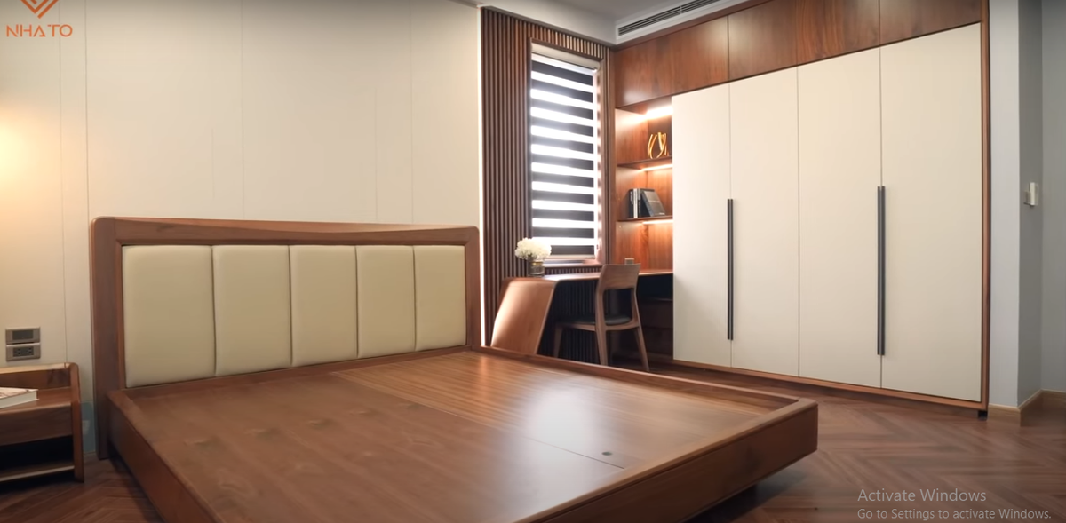 Phòng ngủ sử dụng gỗ óc chó làm điểm nhấn, kết hợp một số vật liệu công nghiệp nhằm tăng tính sang trọng.