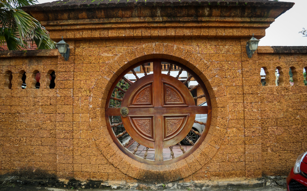 Cổng phụ được thiết kế hình tròn, cánh cửa cũng làm bằng gỗ lim. Ảnh: VTCNews