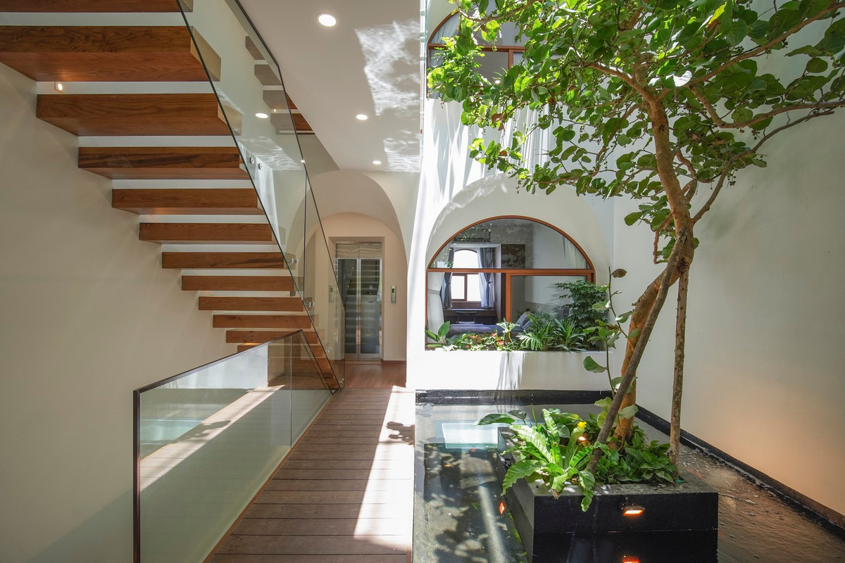 Ở giữa bể cá, thay vì hoàn toàn bằng bê tông, kiến trúc sư sử dụng đáy kính để mang lại nhiều ánh sáng tự nhiên hơn cho khu vực tiếp khách tạm thời ở tầng trệt. Nhờ đó, bể cá có chức năng giống như một chiếc bóng đèn để thắp sáng không gian căn nhà. 