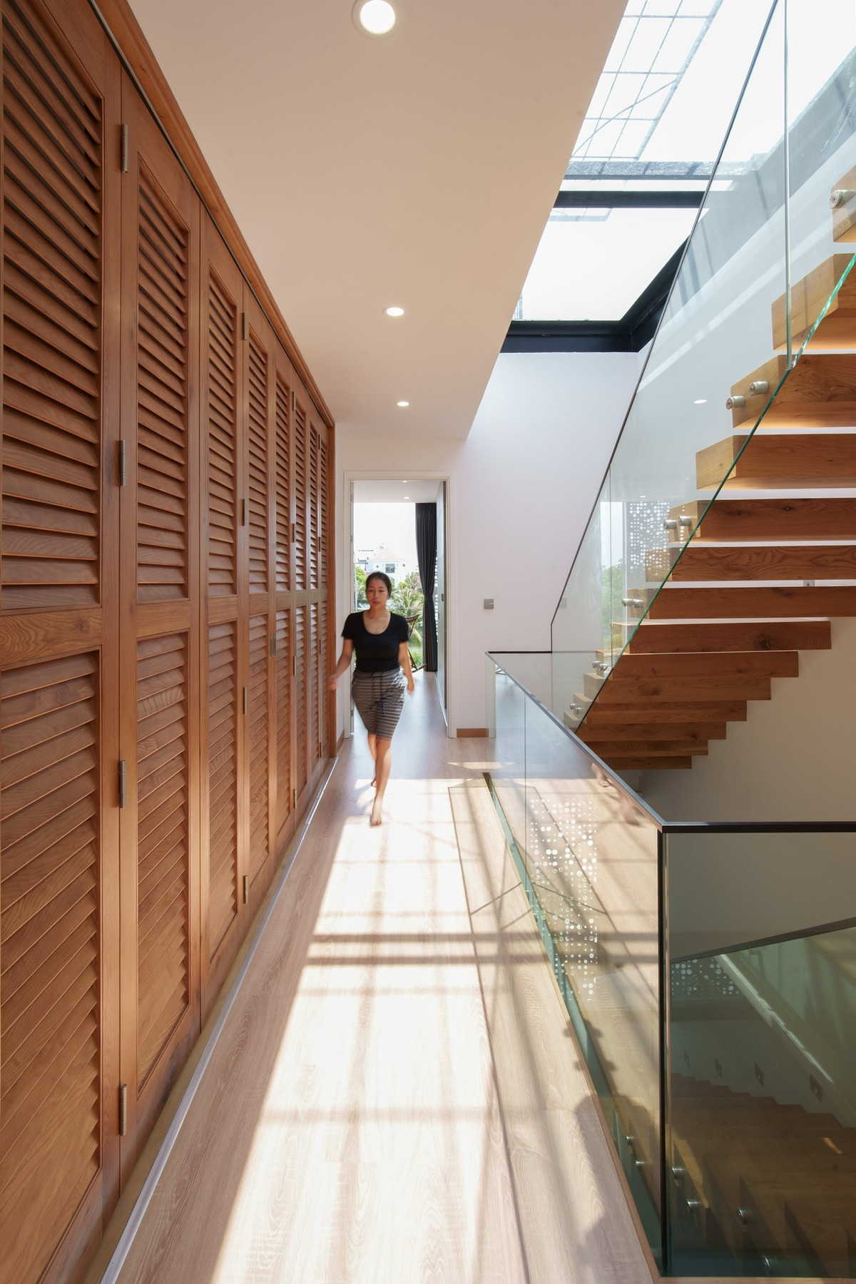 Sự kết hợp giữa gỗ và kính ở cầu thang giúp không gian trở nên tự nhiên và gần gũi hơn.