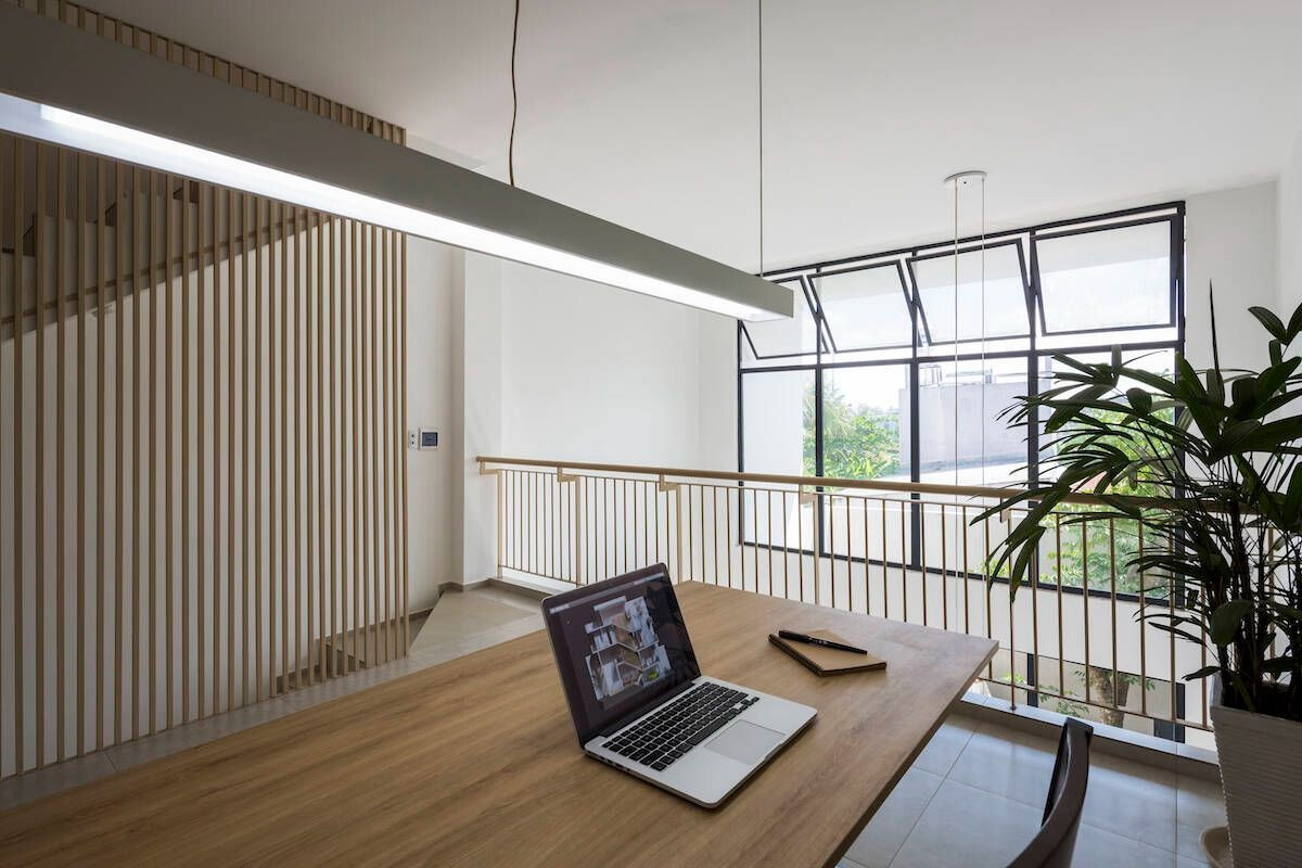 Phòng làm việc ở tầng 1 quay vào sân sau, kết nối với phòng khách bên dưới thông qua khoảng thông tầng rộng.