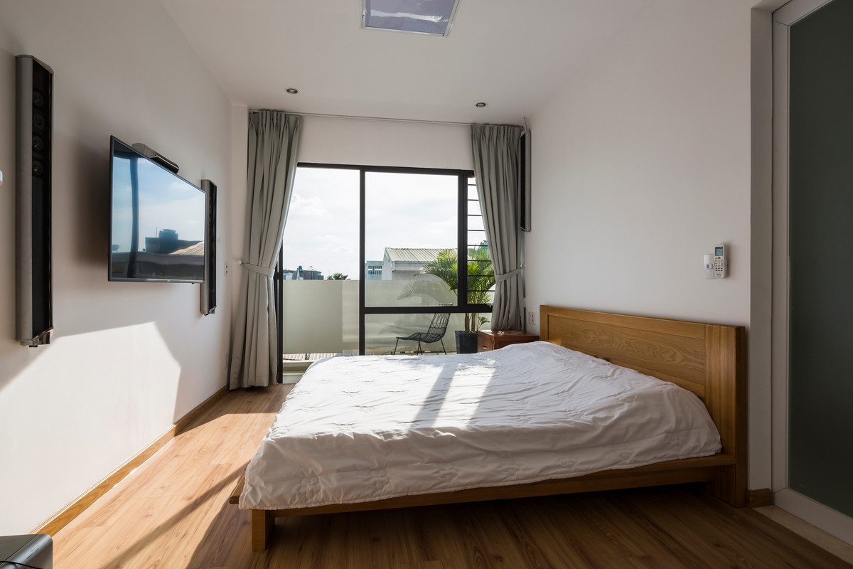 Phòng ngủ chính quay về hướng Tây nhưng được che nắng bởi khoảng lùi lớn và mái lam.