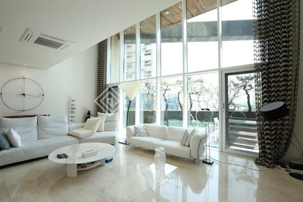 Không gian phòng khách thoáng đãng nhờ có hệ cửa kính. Ảnh: Kpopstarz
