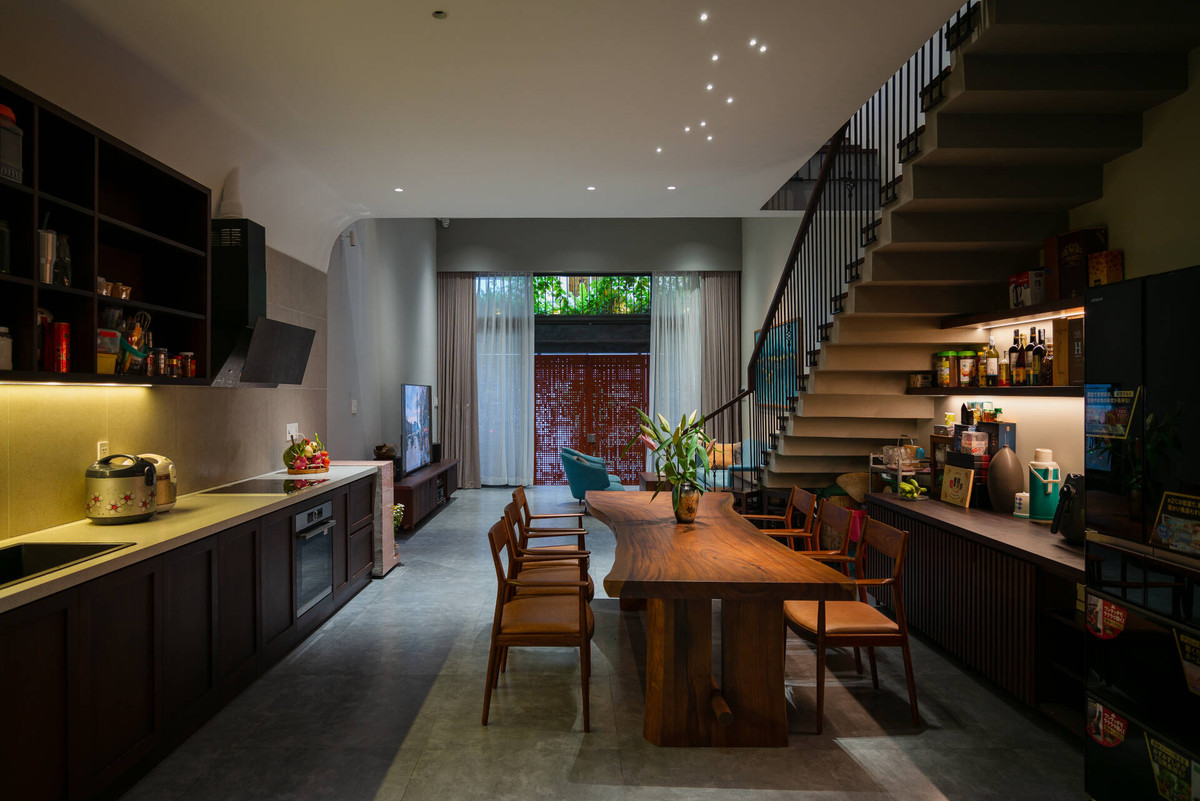 Bếp được đặt cạnh cầu thang, lấy ánh sáng tự nhiên từ phía trước và khoảng giếng trời nhỏ sau nhà.