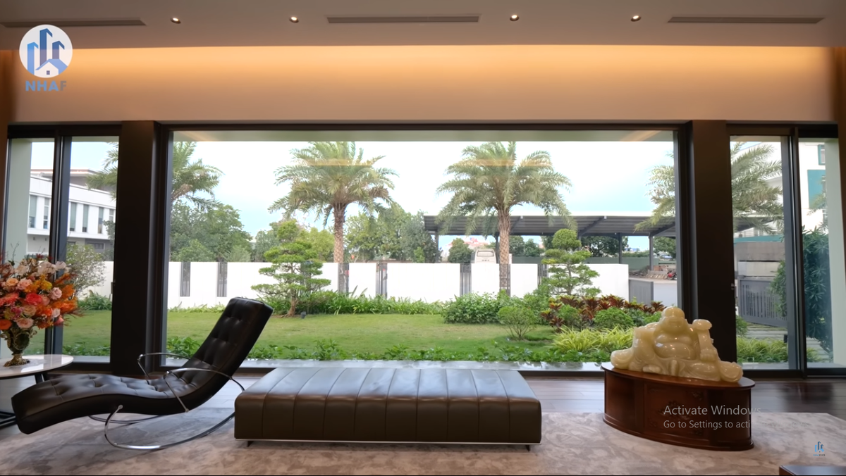 Vách kính cực lớn giúp gia chủ đứng trong phòng khách có thể ngắm trọn khu vườn xanh mướt bên ngoài.