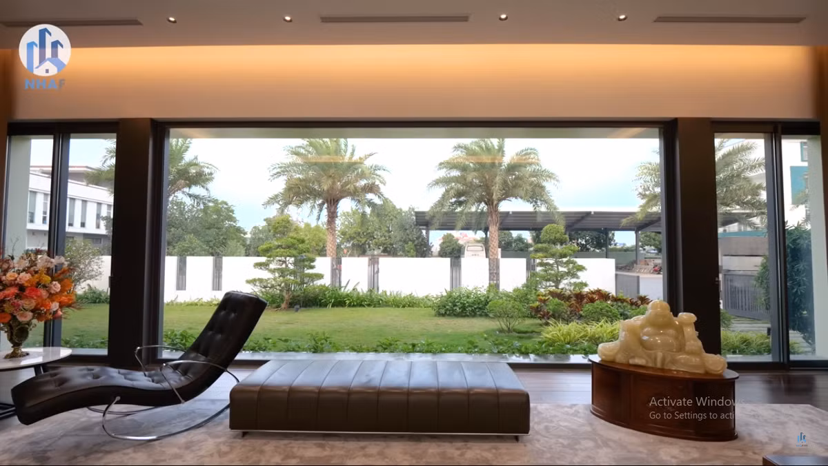 Vách kính cực lớn giúp gia chủ đứng trong phòng khách có thể ngắm trọn khu vườn xanh mướt bên ngoài.