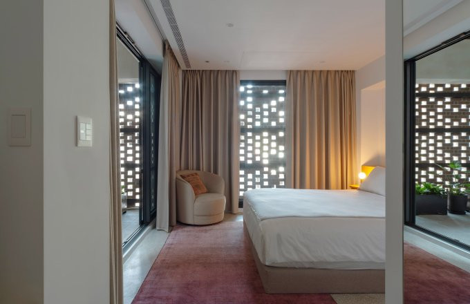 Phòng ngủ đón ánh sáng từ màn gạch xuyên qua lớp kính.