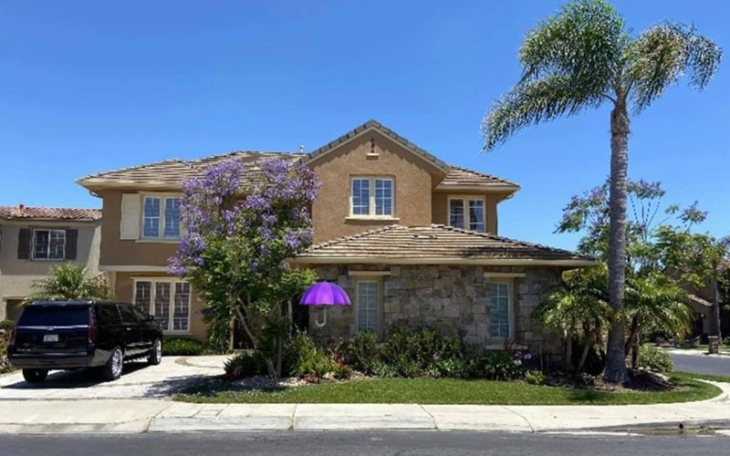 Phía trước biệt thự có sân rộng và nhiều cây xanh.