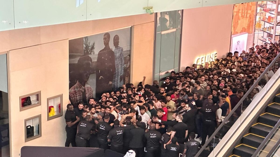 Bất chấp sự can ngăn của nhân viên bảo vệ, nhiều người vẫn cố gắng chen lấn, xô đẩy nhau bên ngoài cửa hàng, khiến nhiều người ngã xuống đất. Ảnh: DM