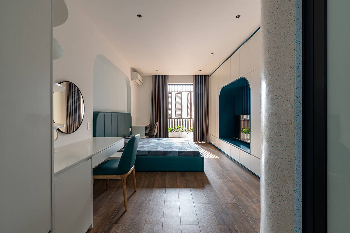 Phòng ngủ trên tầng 2 thiết kế đơn giản, kết hợp hài hòa tường trắng và nội thất màu xanh.