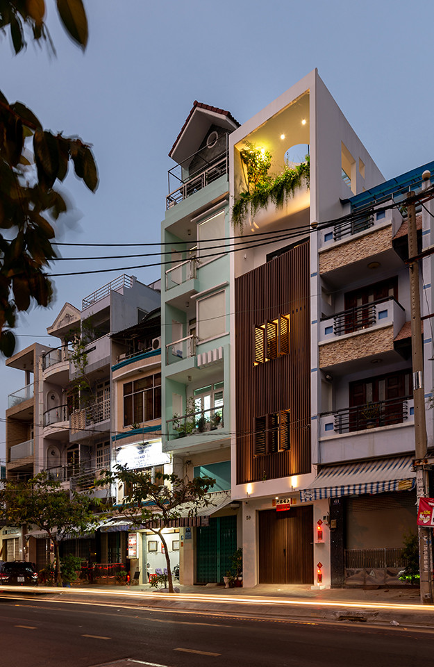 Tuy có mặt tiền thông thoáng, hướng ra đường lớn nhưng ngôi nhà lại chịu nắng gắt hướng Tây và khói bụi từ xe cộ. Để khắc phục nhược điểm này, kiến trúc sư thiết kế một hệ lam chắn kết hợp cửa sổ lam bao trọn lấy 3 tầng nhà.