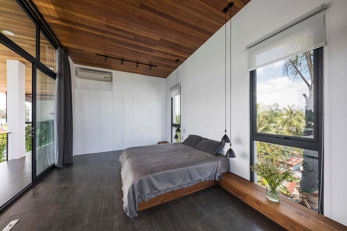 Phòng ngủ master trên tầng 2 có thiết kế đơn giản, tầm nhìn ra sân vườn.