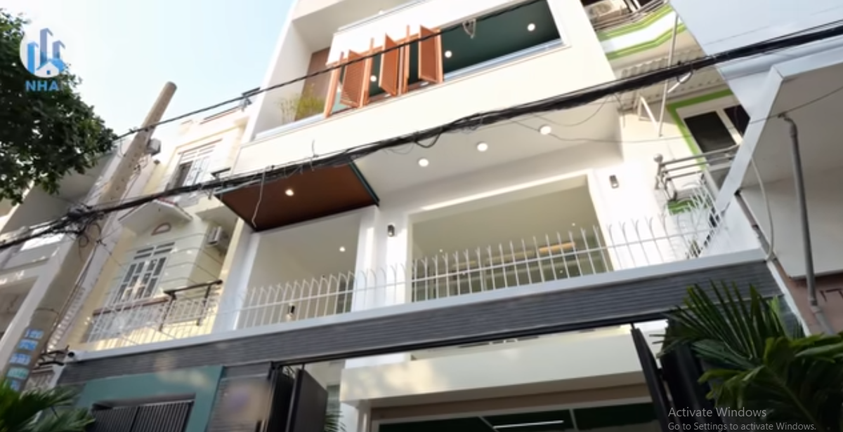 Bên ngoài căn nhà sơn màu trắng chủ đạo và ốp một chút gạch tạo điểm nhấn. Ảnh chụp màn hình NhaF