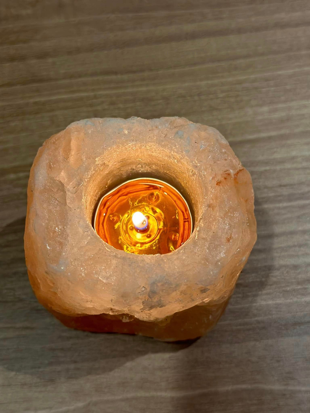 Ánh sáng lung linh từ ngọn nến lấp loá trong viên đá muối.