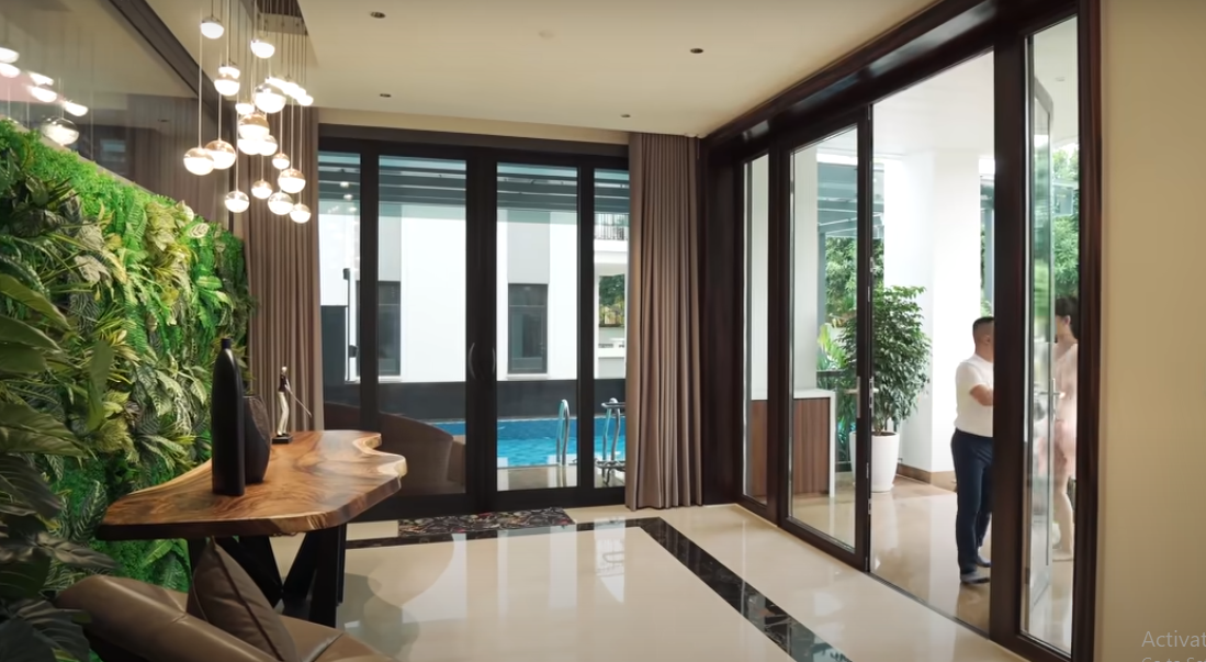 Bước qua cánh cửa là không gian tiền sảnh rộng rãi, nhìn thẳng ra hồ bơi.