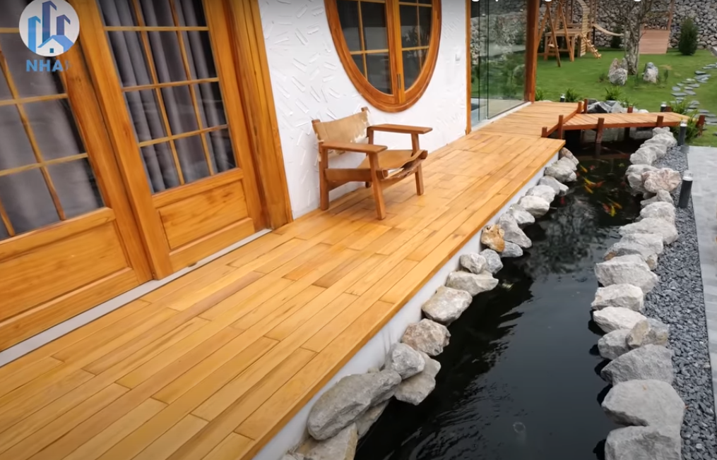 Lối đi quanh nhà được ốp gỗ pơ mu để chống muỗi.