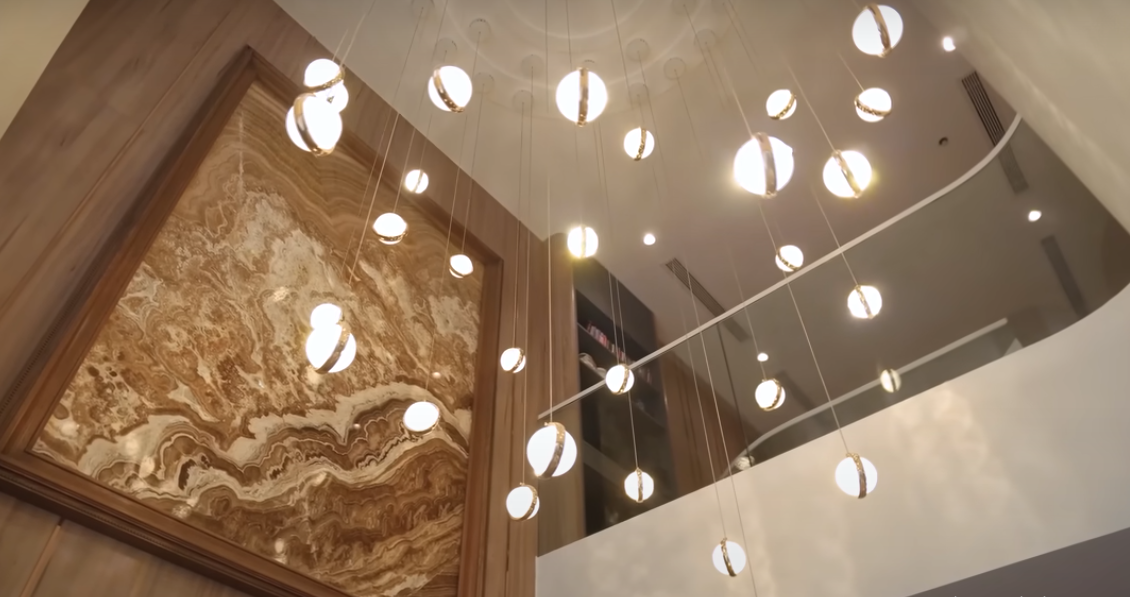 Không gian thông tầng phía trên trang trí bằng bộ đèn chùm dài ngắn khác nhau.