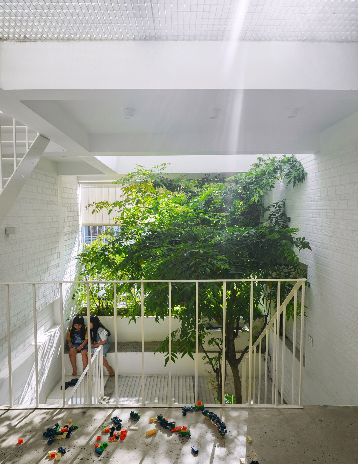 Cấu trúc căn nhà gắn với sân chơi ở phía trước mỗi tầng, mặt bằng chia làm 2 phần, 1/3 không gian phía sau là phòng ngủ, vệ sinh và bếp; 2/3 không gian phía trước là sân chơi đa năng, chỗ học, với ánh sáng tự nhiên và cây xanh.