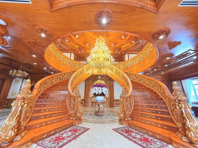 Cầu thang chính giữa sảnh xây theo phong cách cổ điển, hoàn toàn bằng gỗ, được dát vàng 24k làm cho dinh thự thêm phần lộng lẫy. Ảnh: Giadinhonline