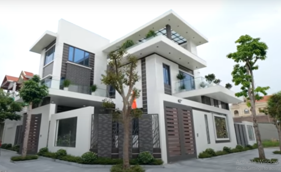 Căn biệt thự gồm 3 tầng nổi với gam màu trắng - nâu tương phản bên ngoài.