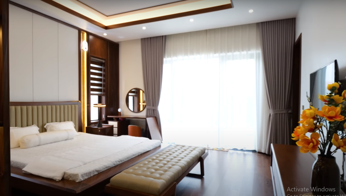 Phòng ngủ master trên tầng 2 cũng sử dụng gỗ óc chó tạo cảm giác ấm cúng.