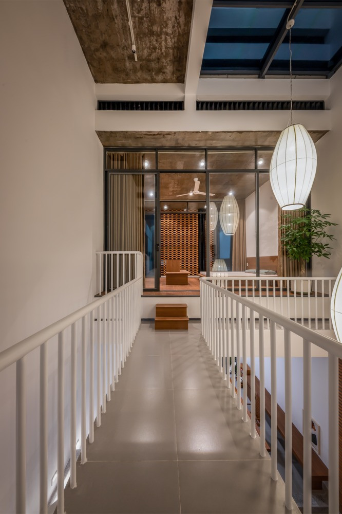 Tầng hai được thiết kế theo nguyên tắc sáng tối đem lại sự thoải mái và ấm cúng. Giữa 2 phòng ngủ là một hành lang kết nối, nơi hiệu ứng bóng đổ diễn ra tạo nên nhiều cung bậc cảm xúc trong cả ngày. Nguồn ảnh: Minq Bui