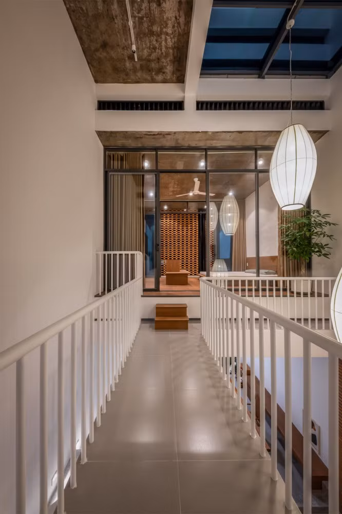 Tầng hai được thiết kế theo nguyên tắc sáng tối đem lại sự thoải mái và ấm cúng. Giữa 2 phòng ngủ là một hành lang kết nối, nơi hiệu ứng bóng đổ diễn ra tạo nên nhiều cung bậc cảm xúc trong cả ngày. Nguồn ảnh: Minq Bui