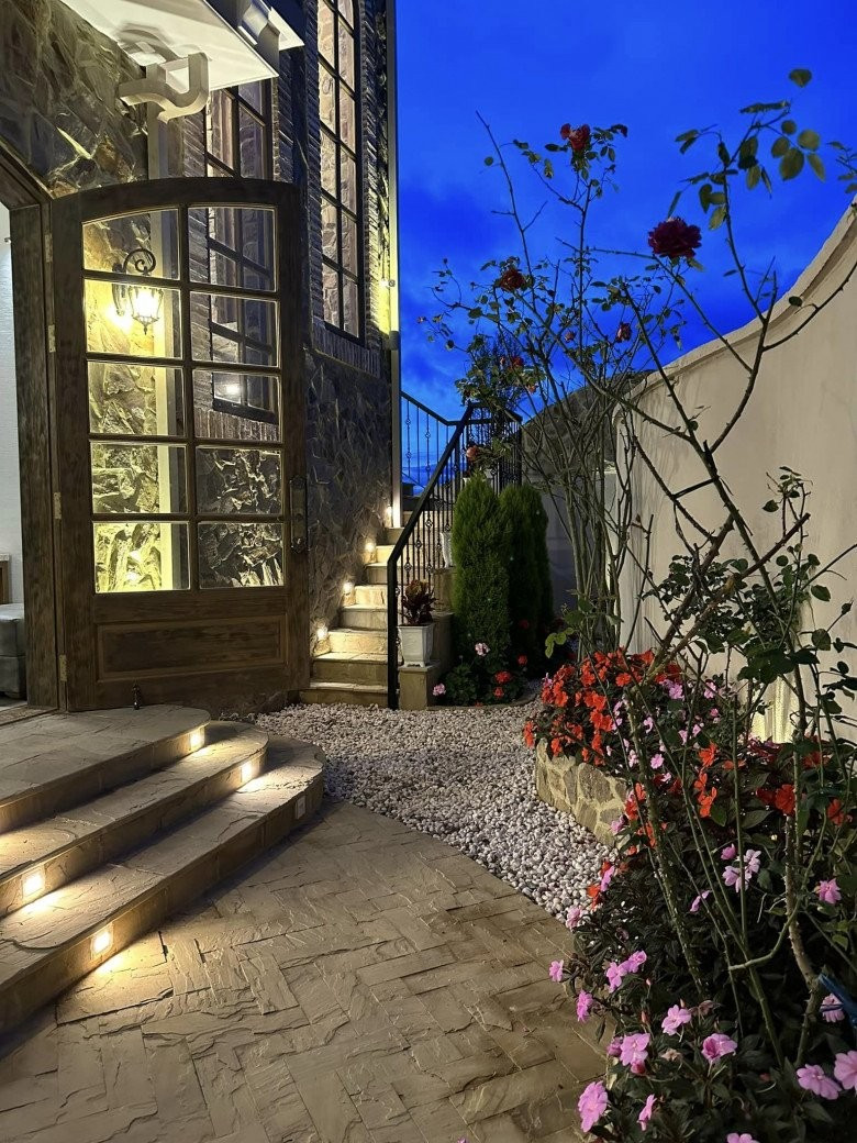 Khu vực sân trồng các loại hoa và trải đá, vừa lãng mạn, vừa ấm cúng, vừa cổ xưa.