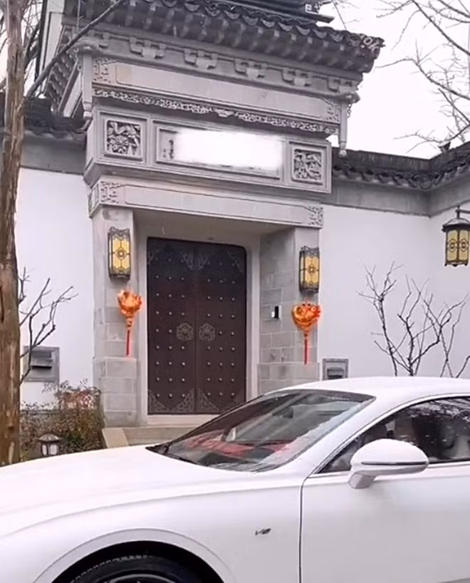 Cổng nhà xây kiên cố với cánh cửa gỗ lớn mang đậm phong cách xưa.