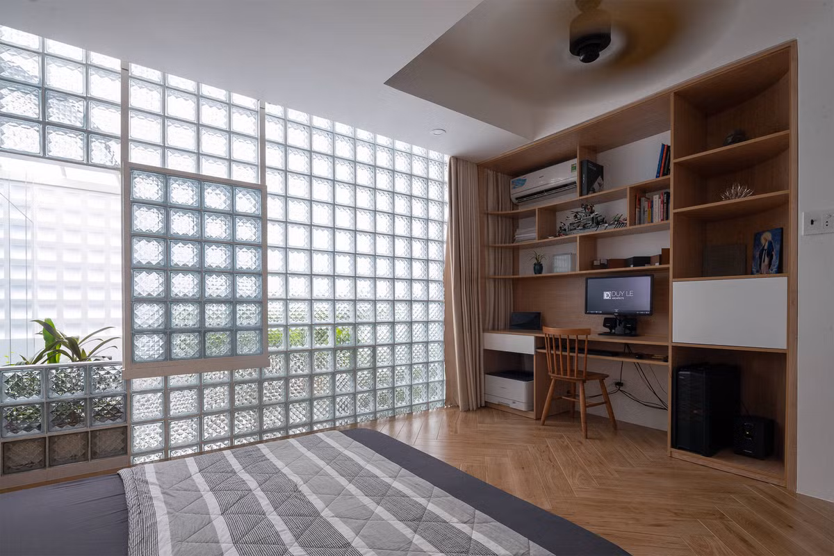 Phòng ngủ kết hợp phòng làm việc sáng thoáng nhưng vẫn đảm bảo sự kín đáo, riêng tư nhờ gạch kính. Nguồn ảnh: Trieu Chien