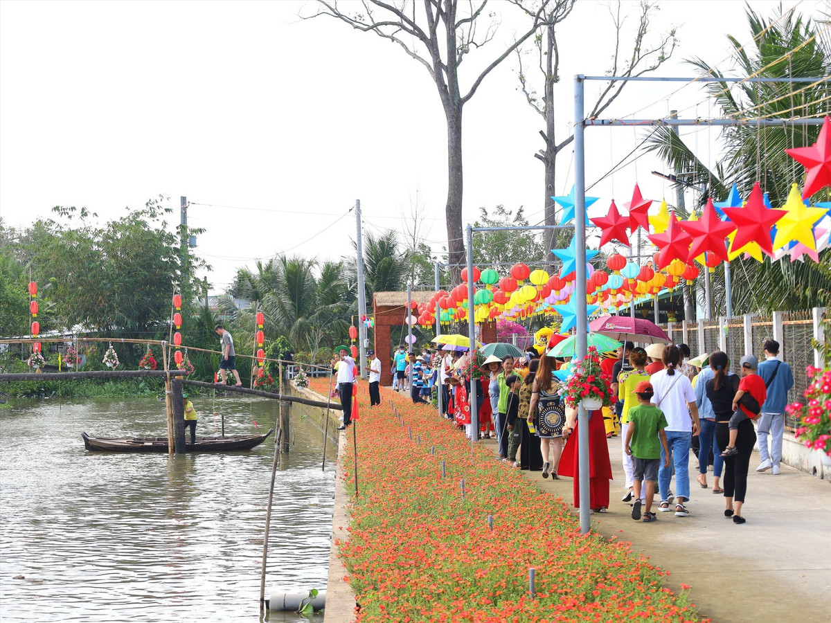 Bên lề đường, hai hàng hoa mười giờ đủ màu sắc uốn lượn dọc bờ kênh. Ảnh; Lao động