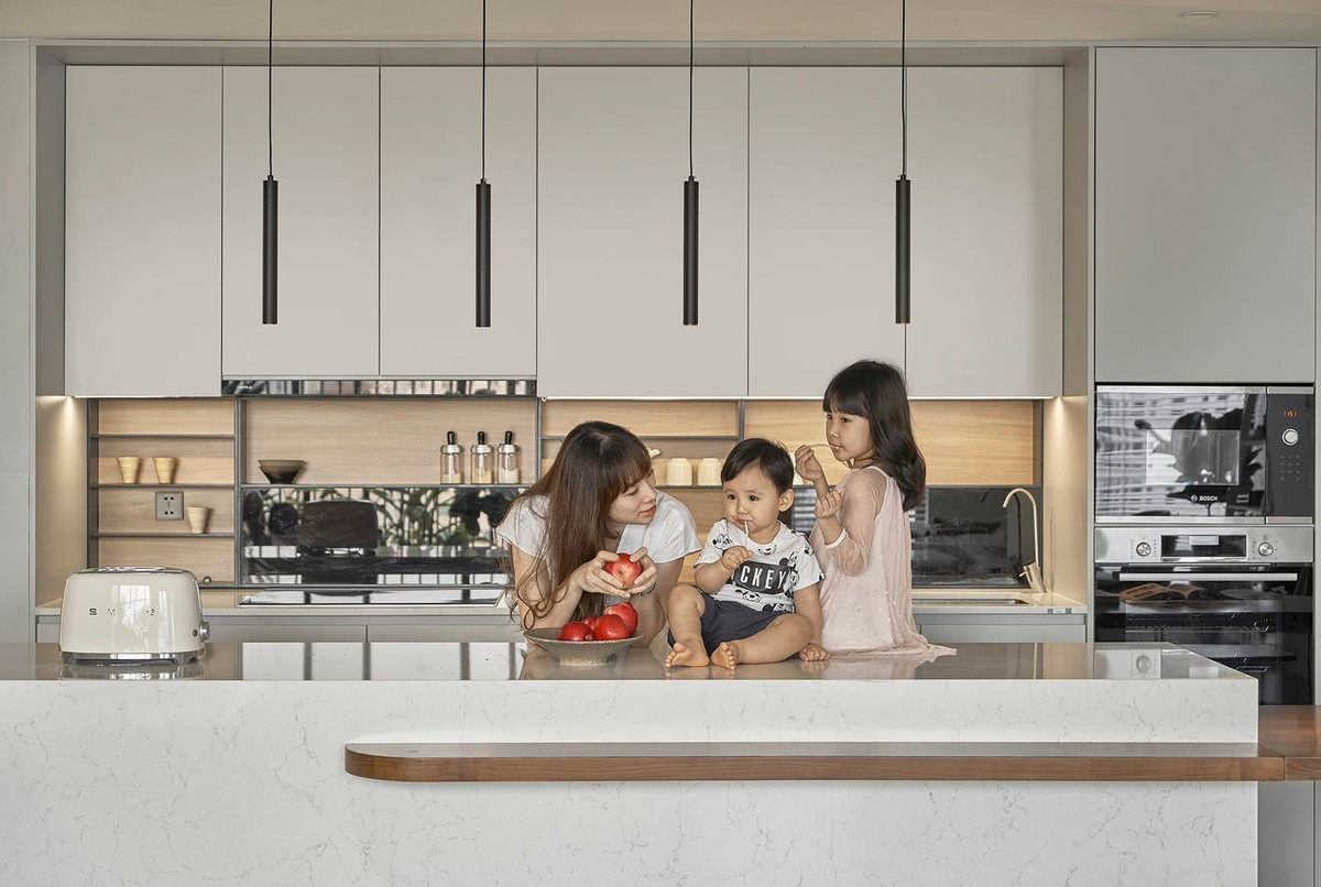 Bàn đảo của bếp được tích hợp, kéo dài thêm một bàn ăn dài. Ảnh: Reatimes