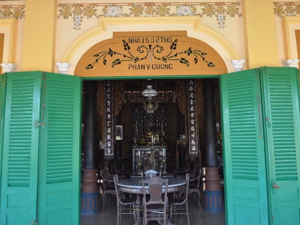 4 cột làm từ gỗ căm xe, giữa gian chính treo 2 câu đối và bộ tủ thờ gia tiên được khảm trai công phu. Ảnh: Mia