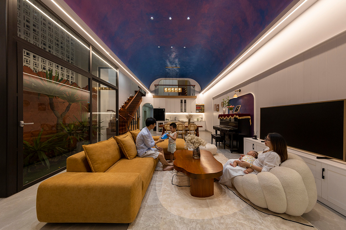 Tầng 1 là không gian phòng khách, nhà bếp và phòng ăn. Trần được nâng cao, phối màu như bầu trời sao.