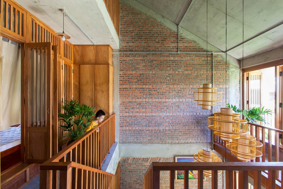 Tầng 2 được khoét đi tạo thông tầng kết hợp cầu thang gỗ, giúp tạo ra sự kết nối giữa hai tầng.