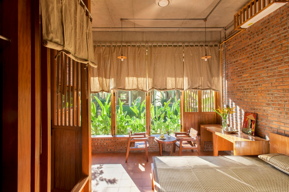 Trong nhà có sự phân chia phòng khách và phòng ngủ bằng cửa gỗ và rèm.