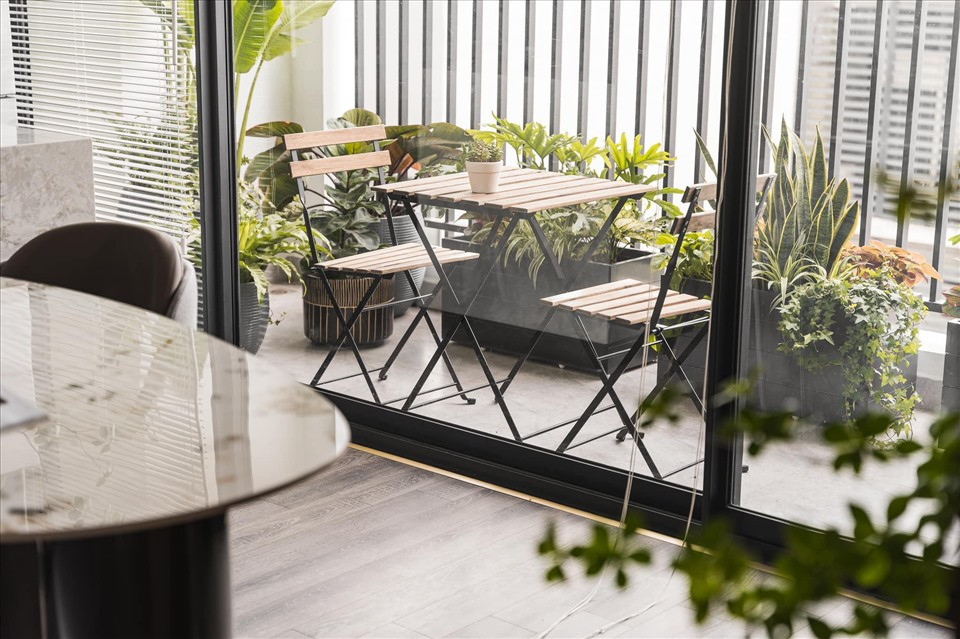 Khu vực ban công được trồng nhiều cây cảnh, có bàn ghế để uống trà, thư giãn.